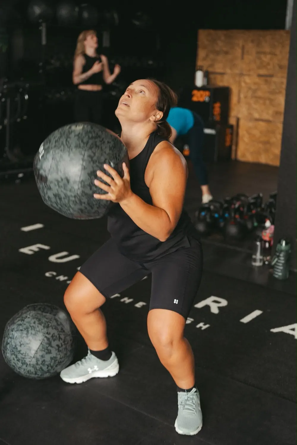 Member squatting with a wall ball